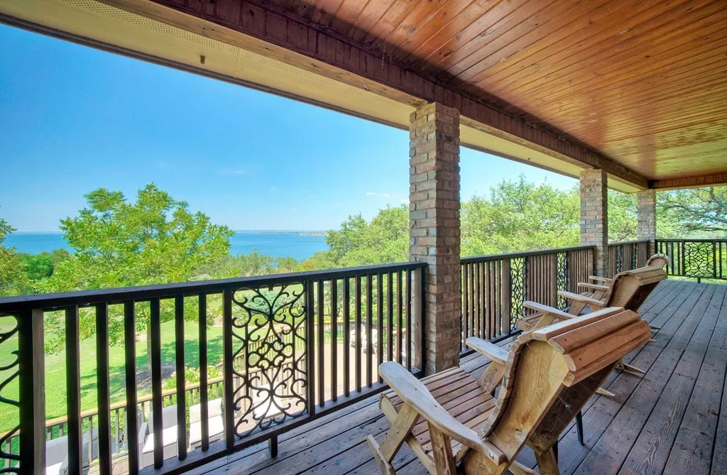 Covered deck with wooden lounge chairs overlooking the lake