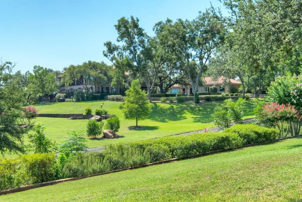 View across the lawn toward the guest house and main house among the trees