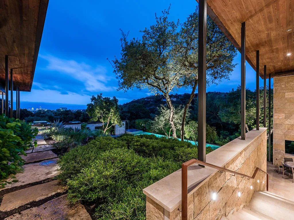 View from the covered porch at dusk, overlooking the infinity pool and hillside